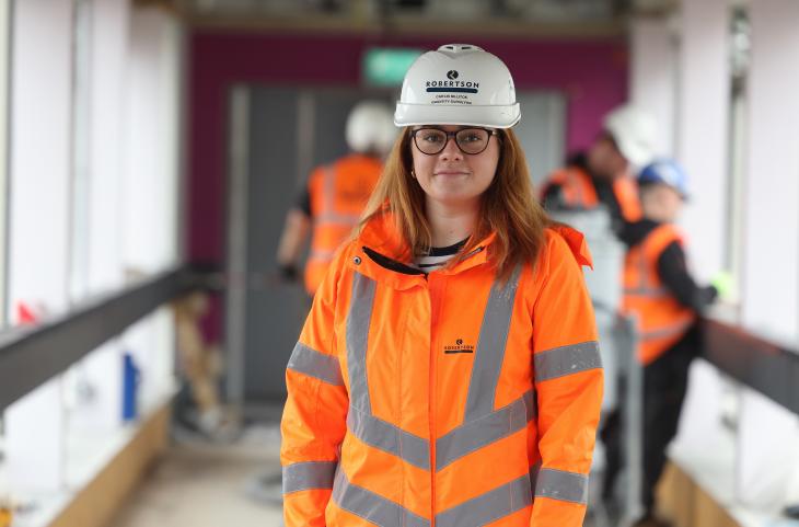 A member of Robertson Construction. A Young woman looking at the camera, wearing PPE.