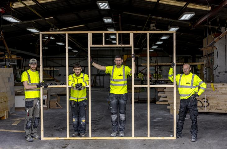 Robertson Timber Engineering team holding a timber frame.