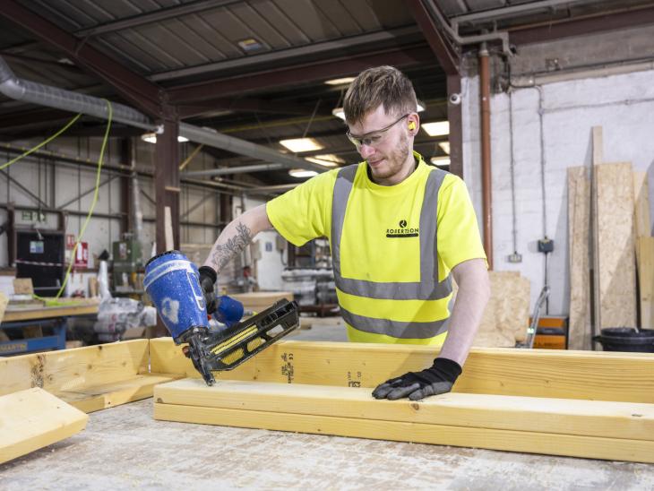 Robertson Timber Engineering employee nailing a timber frame at the Elgin Factory