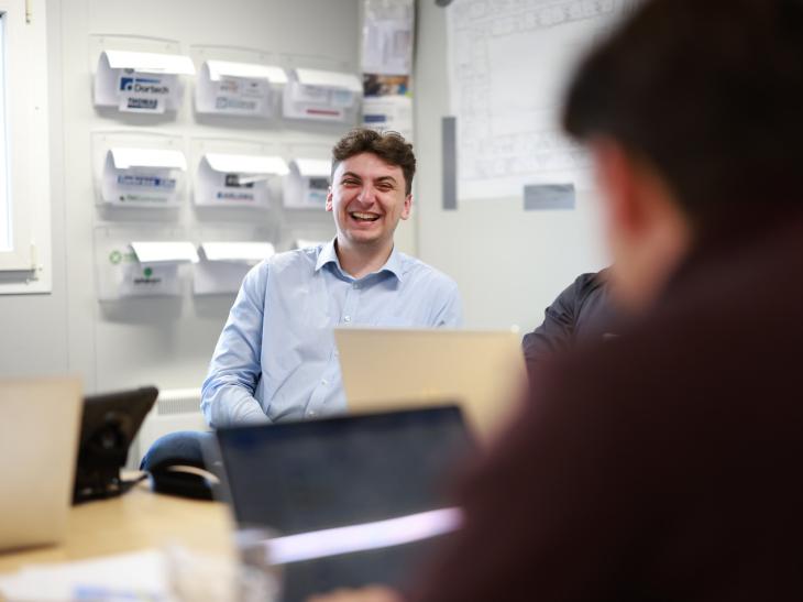 Summer intern with colleagues in construction company office