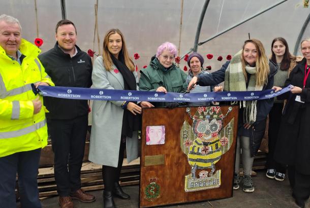 Row of people cutting a ribbon with wooden lectern in centre