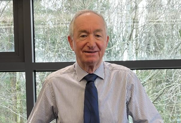 headshot of a business founder in striped shirt and blue tie