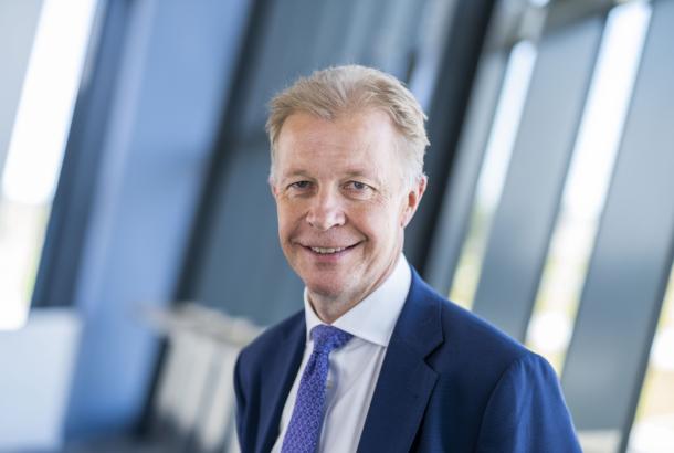 Man with light hair wearing a navy suit and blue tie in front of an industrial background, he is the CEO of RFM, a Robertson Group supported business