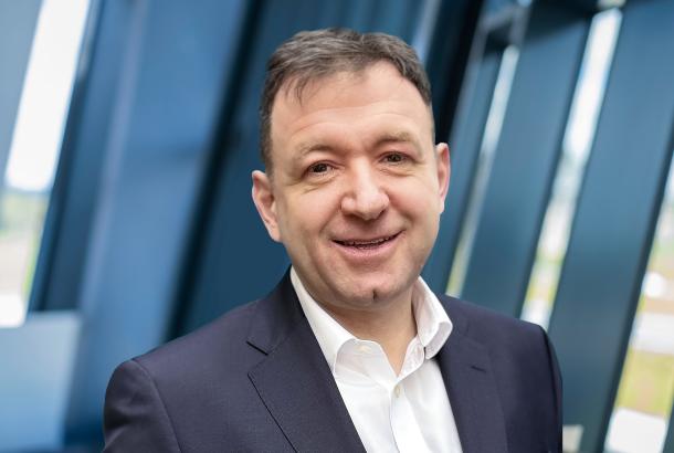 Headshot of business executive with blue suit and white shirt