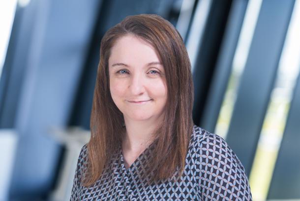 headshot of a female business executive in black white and red patterned dress
