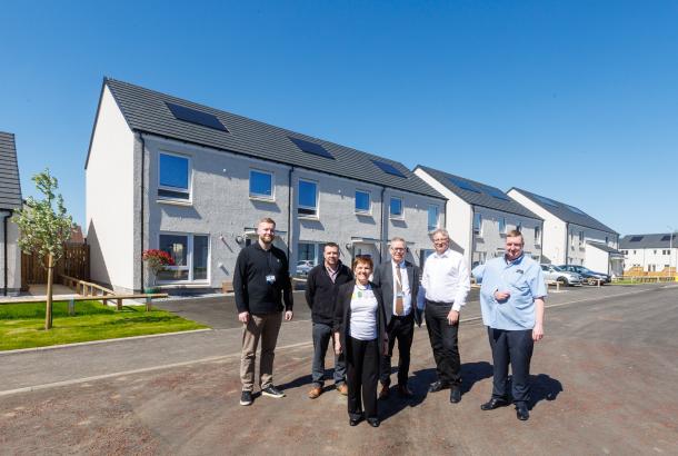 People stood in front of new affordable housing with blue skies, marking the handover of the Viewfield development delivered by Robertson for Fife Council