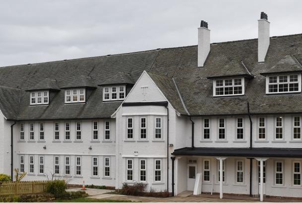 Image of exterior of building with white walls and grey roof tiles