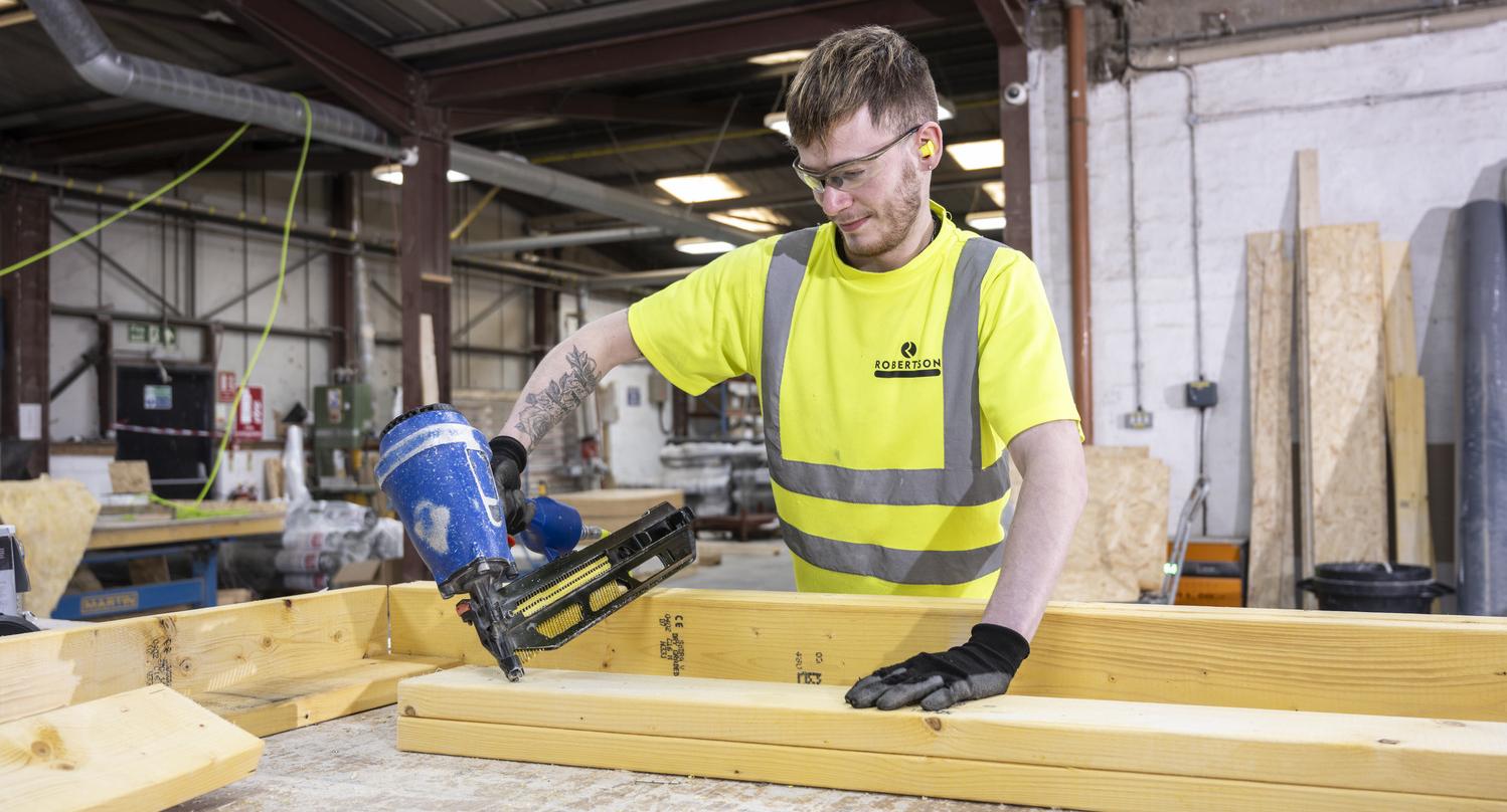Robertson Timber Engineering employee nailing a timber frame at the Elgin Factory