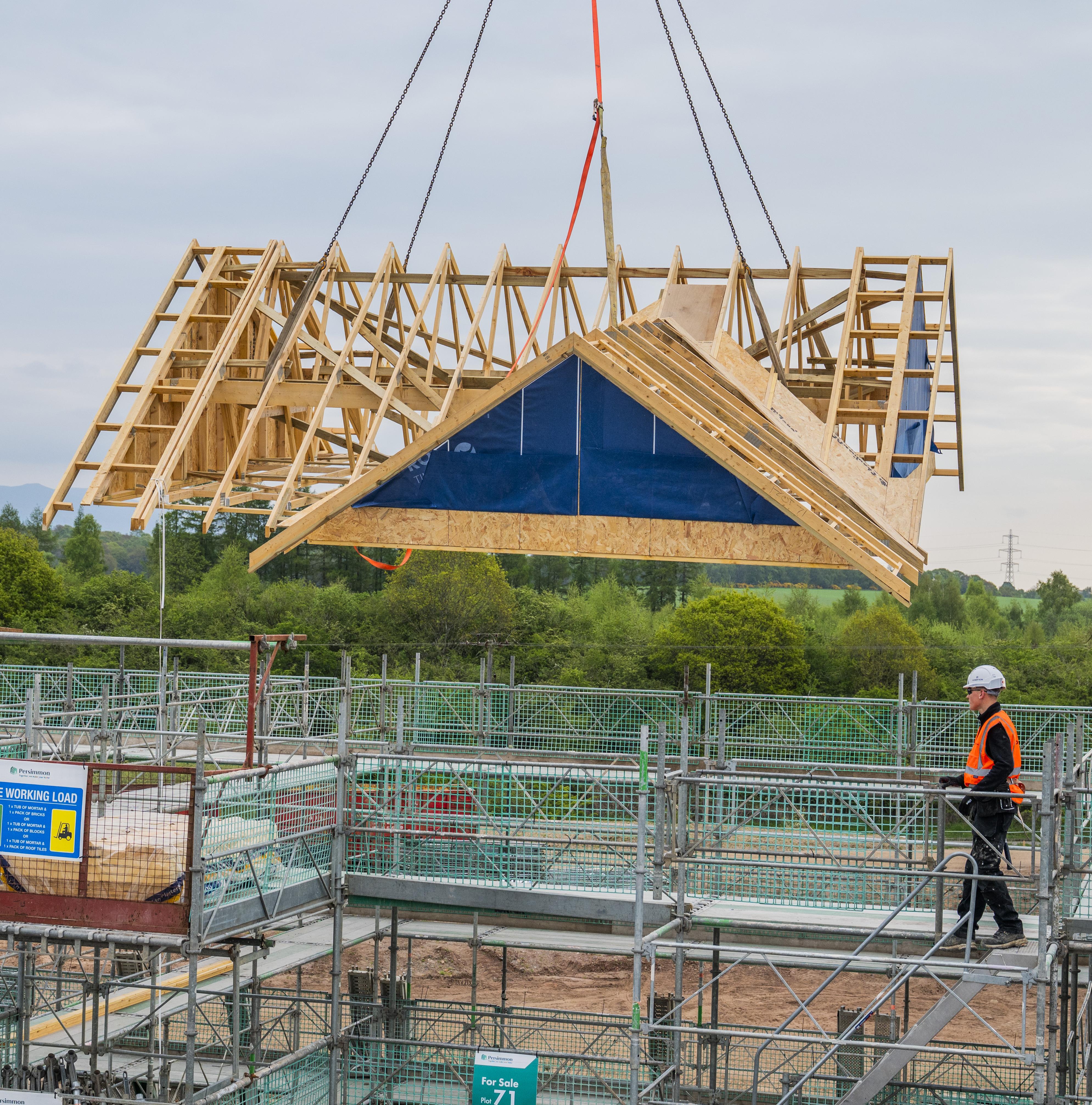 Timber frame roof manufactured off site being craned into place