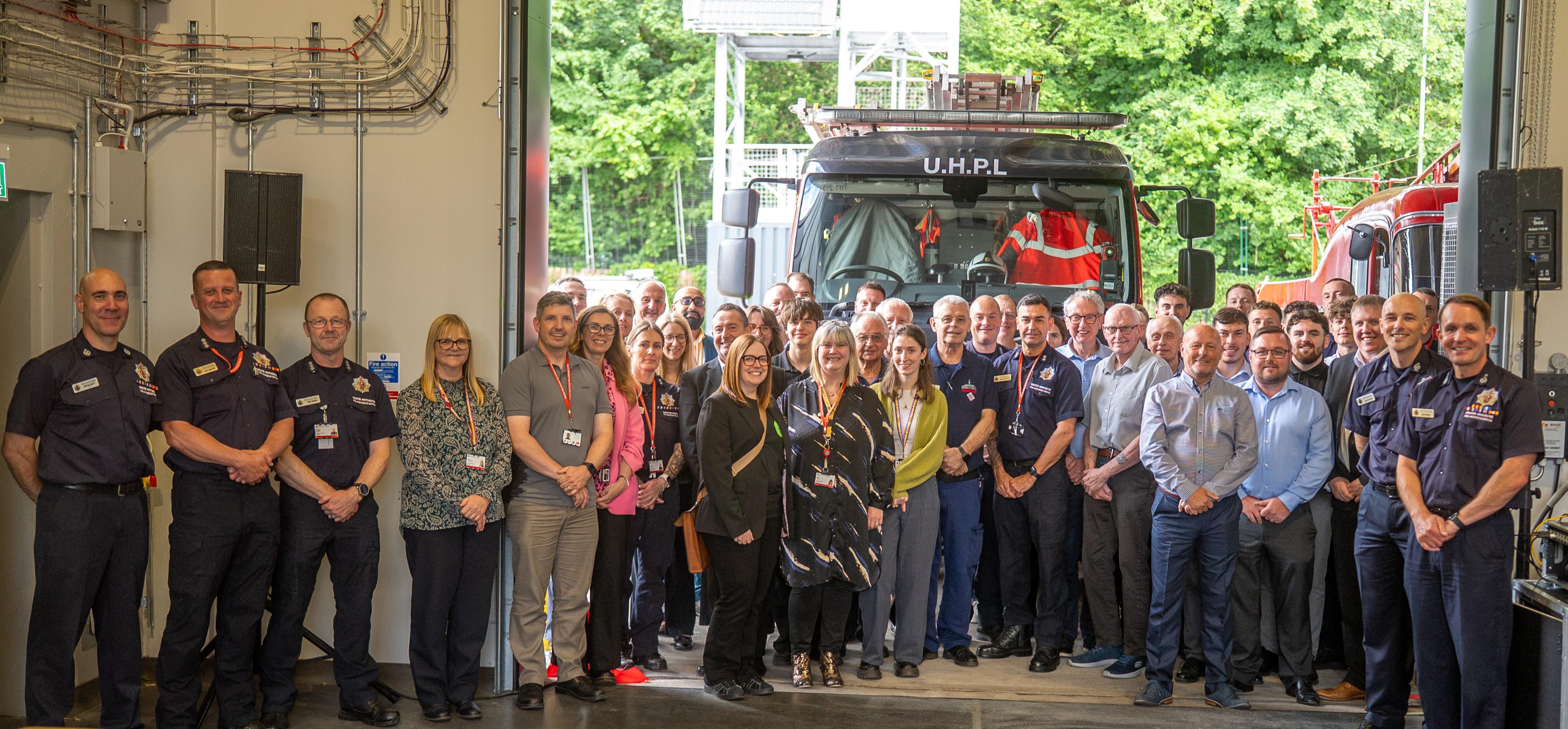 Blackley Community Fire Station official opening. GMFRS, Robertson and project partners gathered around a fire engine in the new station.