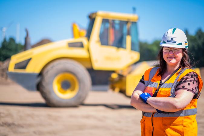 Image of a young female civil engineer with her arms crossed, standing in front of plant, looking at the camera.