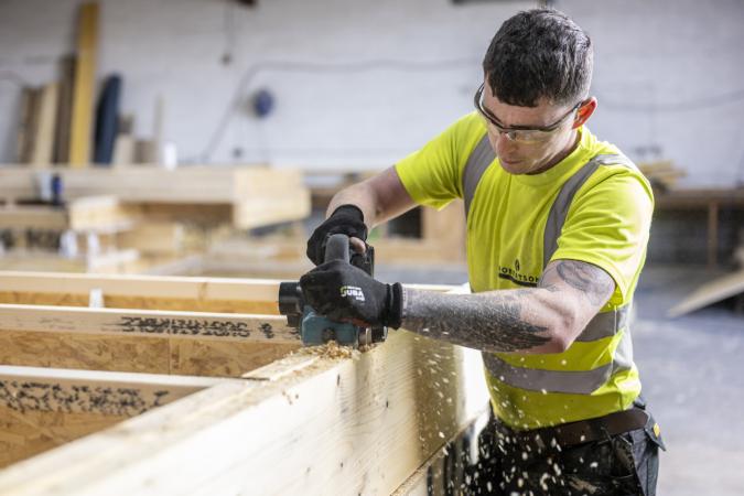 Robertson Timber Engineering employee planing timber at the Elgin Factory