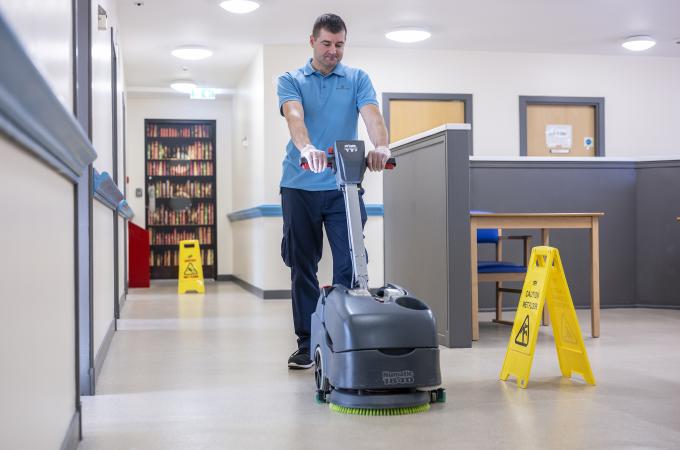 Facilities management - man performing soft FM, maintenance, cleaning of public sector assets