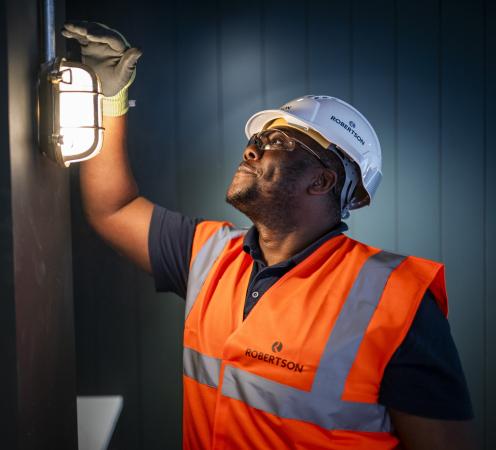 Construction worker in protective clothing examining new lighting