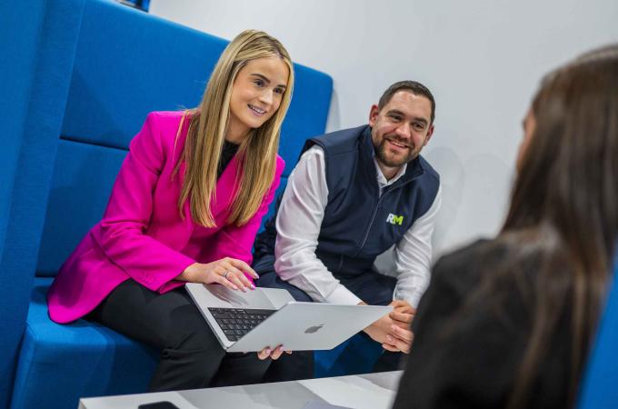 Man in RFM branded vest and woman in pink jacket having meeting