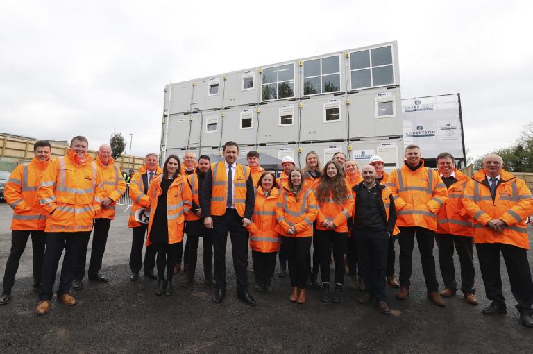 The Robertson Construction Mynnyd Isa team with CEO Elliot Robertson. All standing outside and wearing our iconic orange jackets.