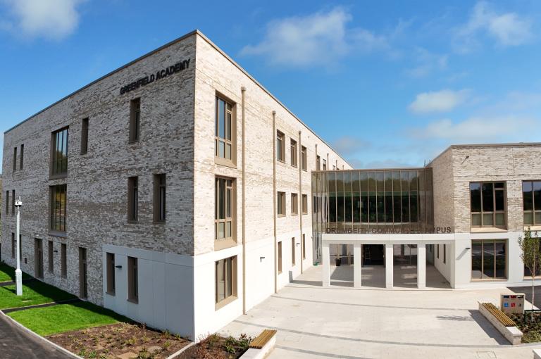 External drone image of Drumgeith Community Campus and Greenfield Academy, high-quality brick building with blue sky