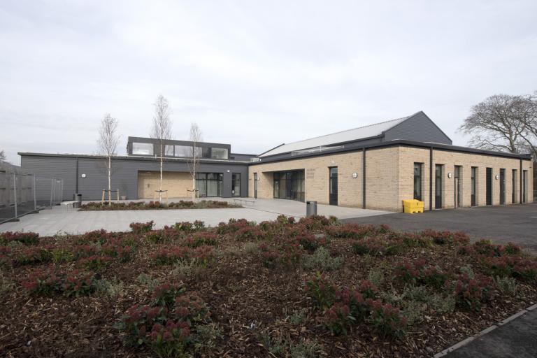 Exterior of school with shrub garden in foreground