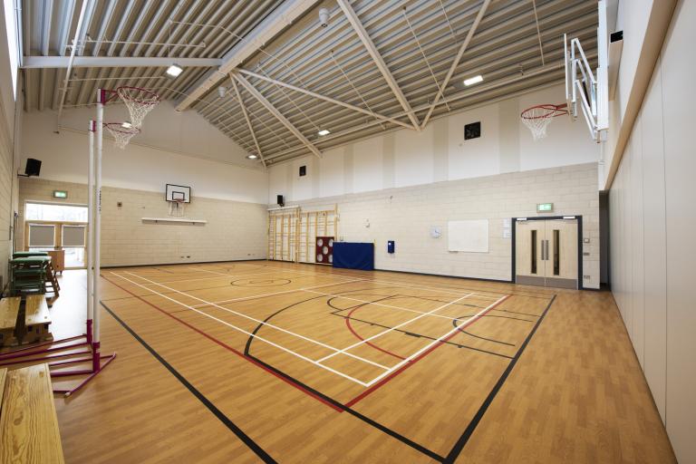 Empty gymnasium with sports courts marked on floor