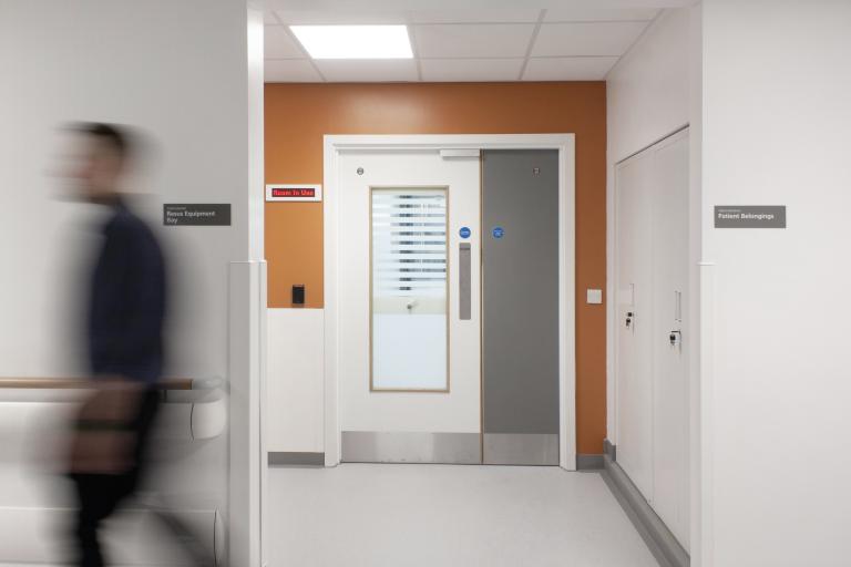 NHS staff member walking through a corridor in the Freeman Hospital, Newcastle, where Robertson Construction North East delivered a strategic refurbishment for the Trust