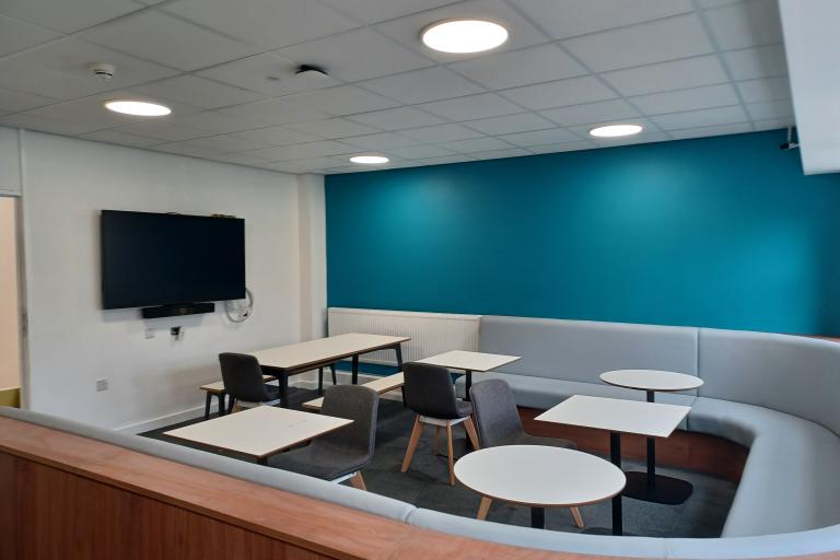 Classroom area with tv, desks and seating area