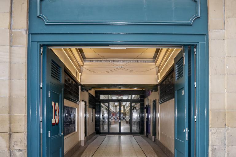 New entrance to Grainger Market with new mosaic tiling and an LED overhead sign on stonework, delivered by Robertson for Newcastle City Council