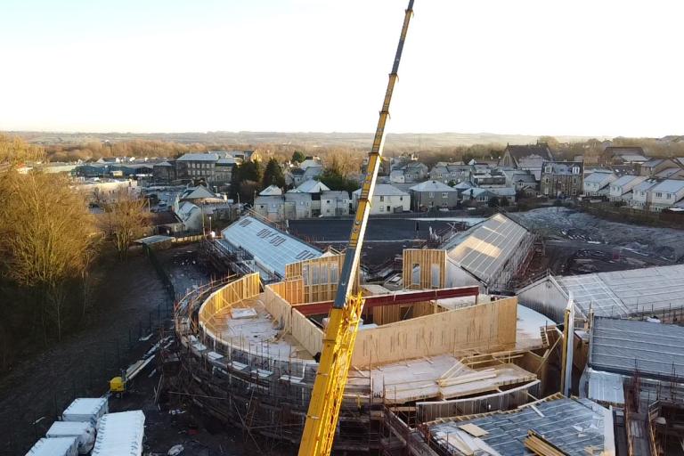 Mass timber built school with crane erecting timber