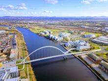 An aerial view of Teesside University on a sunny day with the iconic bridge in the foreground.