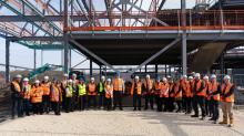 Group of people standing outside with PPE on at the steel signing ceremony for Chesterfield College's new Advanced Manufacturing and Life Sciences building, being delivered by Robertson Construction