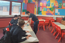 Robertson social impact manager in a classroom presenting the Robertson employability programme, Ideal Candidate, to pupils