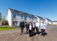 People stood in front of new affordable housing with blue skies, marking the handover of the Viewfield development delivered by Robertson for Fife Council