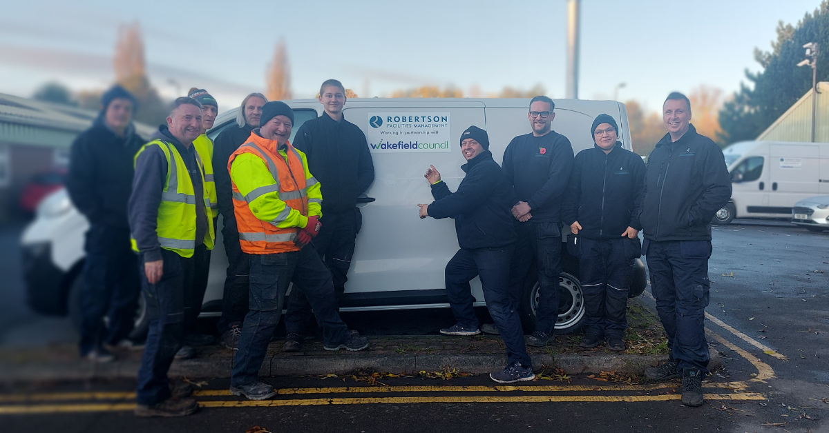 Robertson Facilities Management employees by the newly wrapped Wakefield Council and RFM van