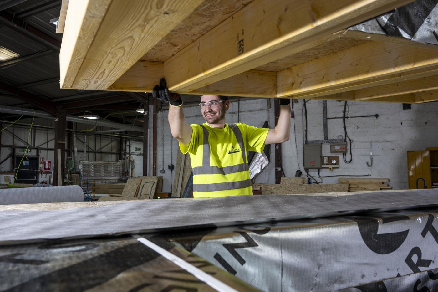 Robertson Timber Engineering employee carrying timber at the Elgin Factory