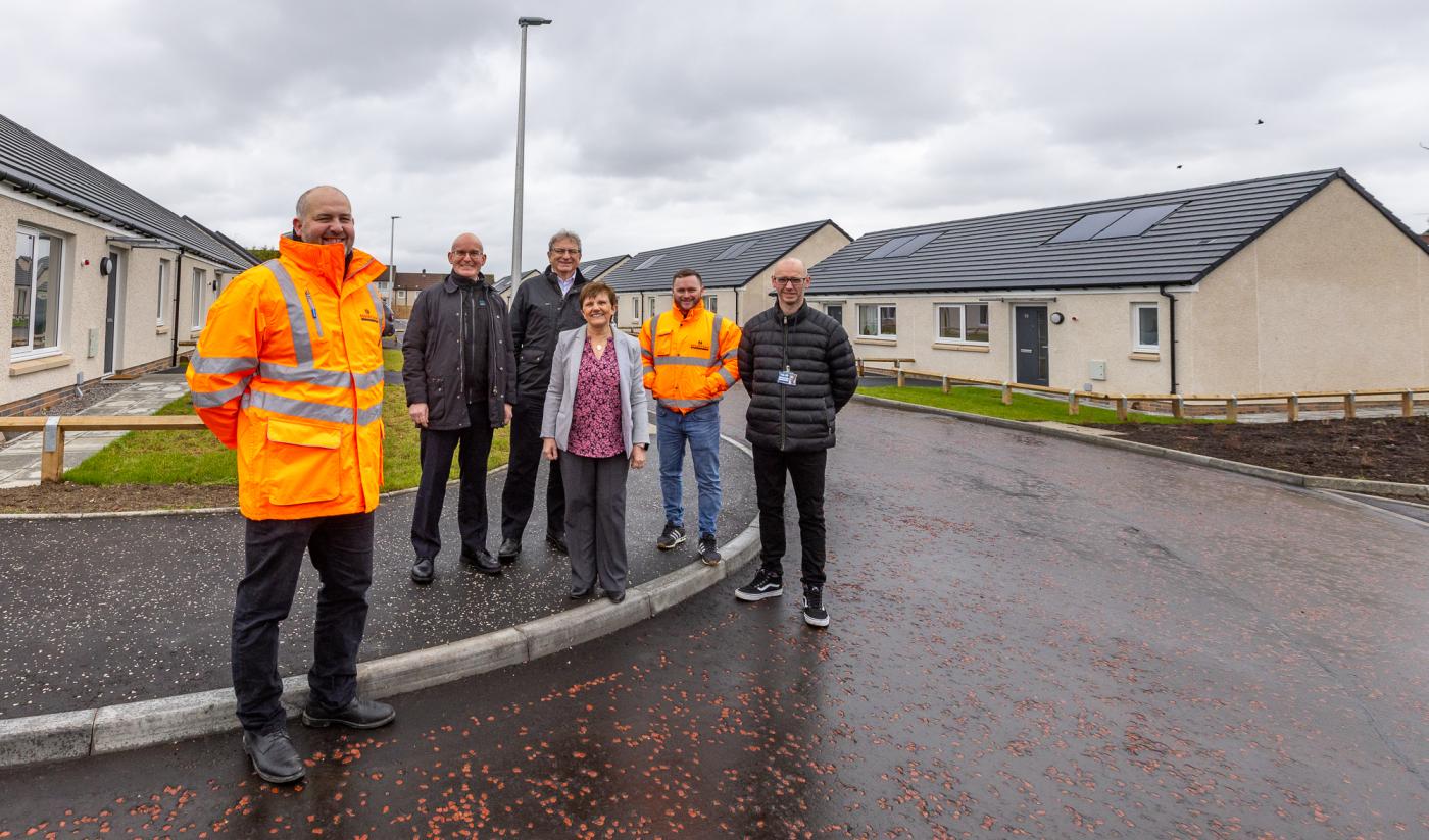 Fife Council and Robertson employees standing at the new Pitcorthie housing development in Dunfermline, delivered by Robertson Construction