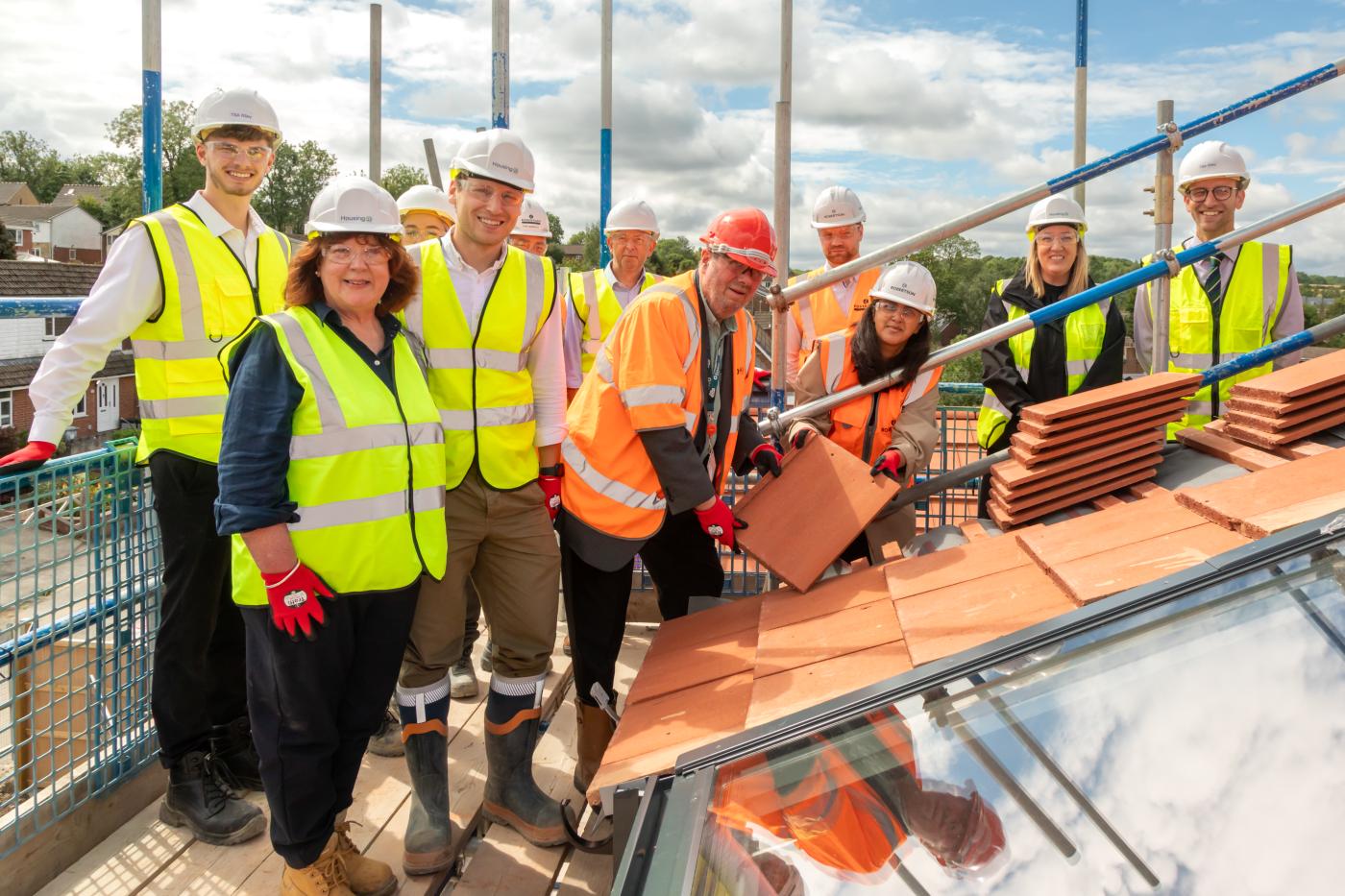 Kirklees Council laying a roof tile to mark the milestone with the project team